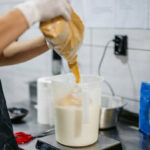Young man preparing ice cream batter in an ice cream shop. Close-up.