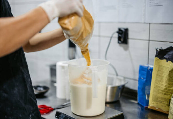 Young man preparing ice cream batter in an ice cream shop. Close-up.