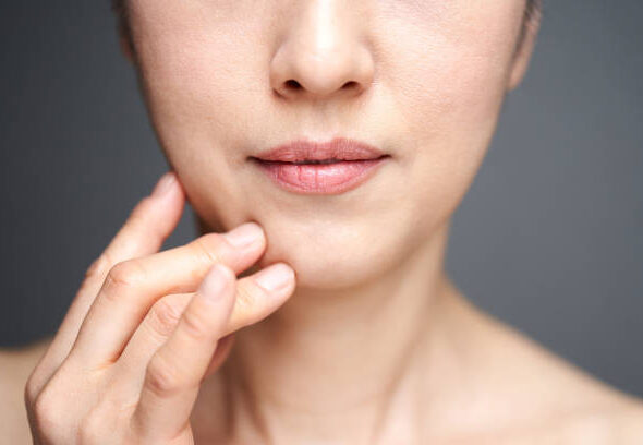 Middle-aged Japanese woman worried about wearing a cheek stick
